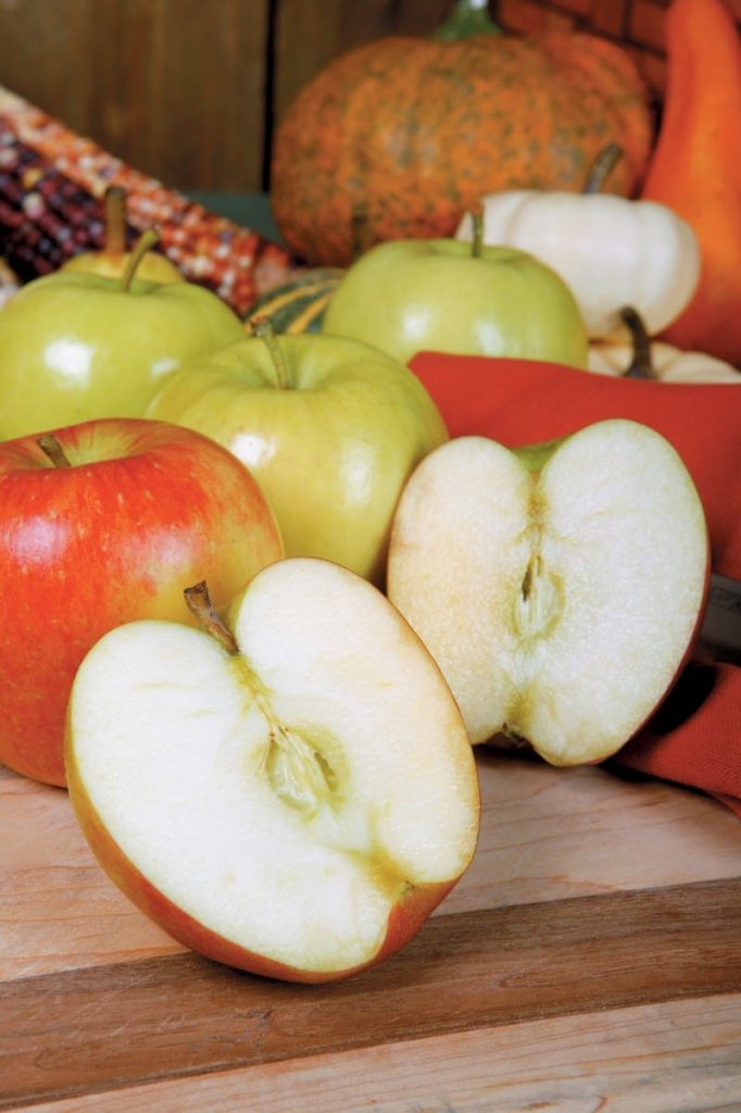 Whole and Halved Assorted Apples on Wooden Surface Food Picture