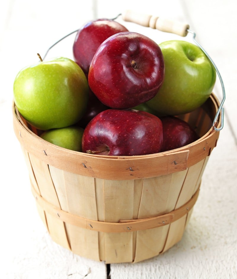 Orchard Fresh Granny Smith and Red Delicious Apples in Wooden Basket on Stained Wooden Deck Food Picture