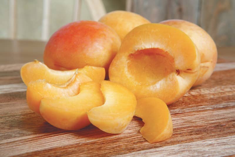 Whole and Sliced Apricots on Wooden Surface Food Picture