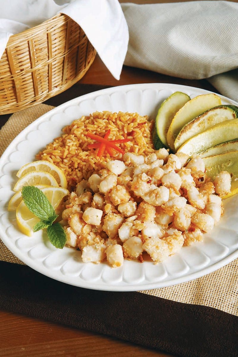Bay Scallops and Rice on a Plate with Pickles and Lemon Slices Food Picture