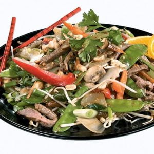 Orange Beef Stir Fry on Black Plate with Red Chopsticks Food Picture