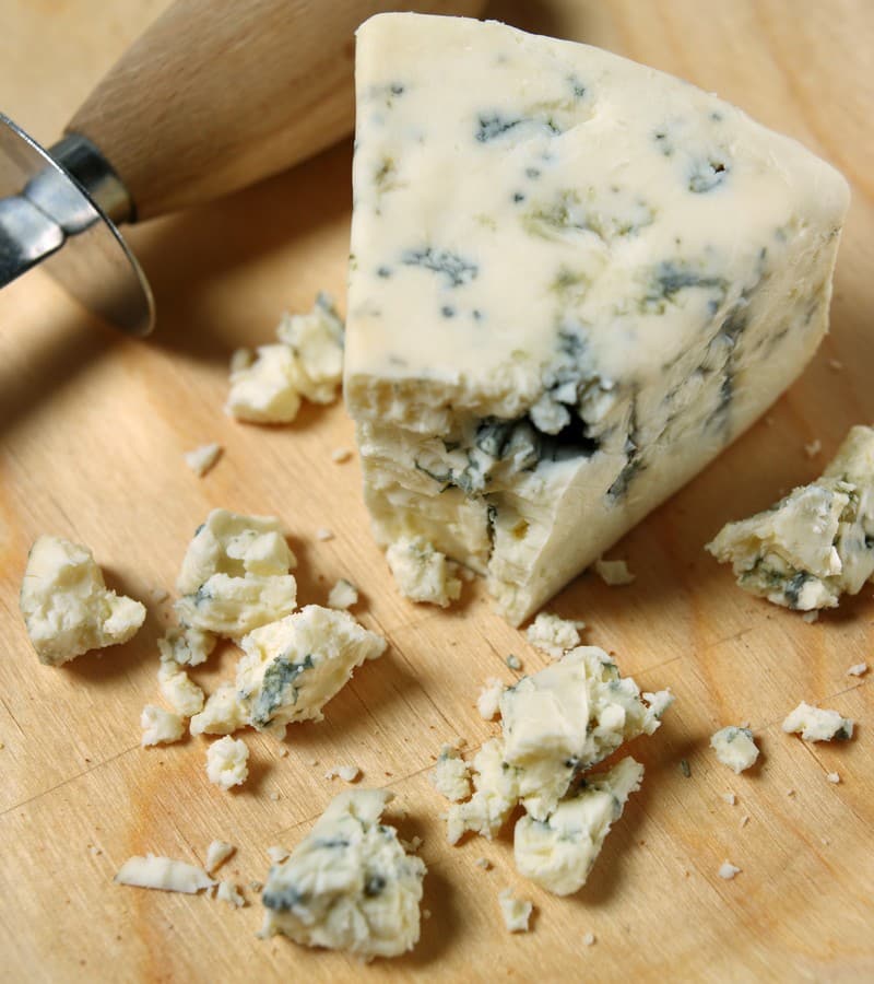Blue Cheese Wedge and Crumbles on Cutting Board Food Picture