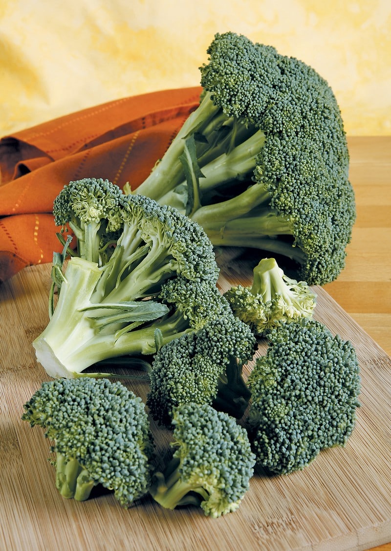 Broccoli on wooden surface with orange napkin Food Picture