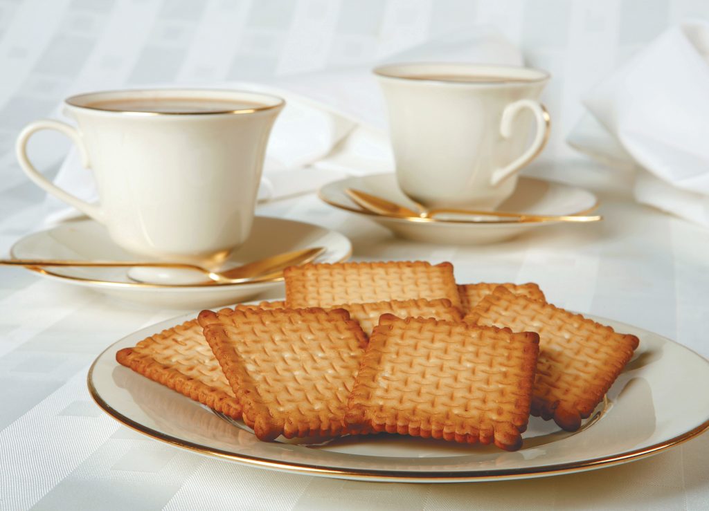 Fresh Butter Biscuits on White Plate with Tea Cups and Saucers on White Tablecloth Food Picture