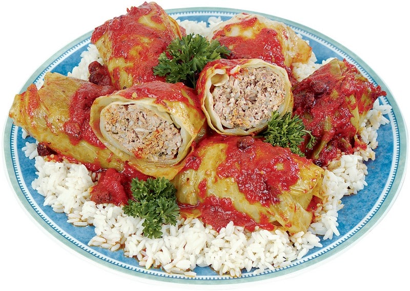 Stuffed cabbage with rice on a blue plate with sauce and garnish on a white background Food Picture