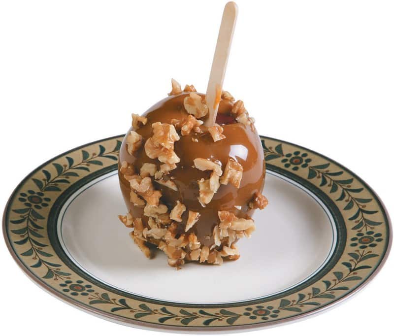 A Caramel Apple with Nuts in a Plate Food Picture