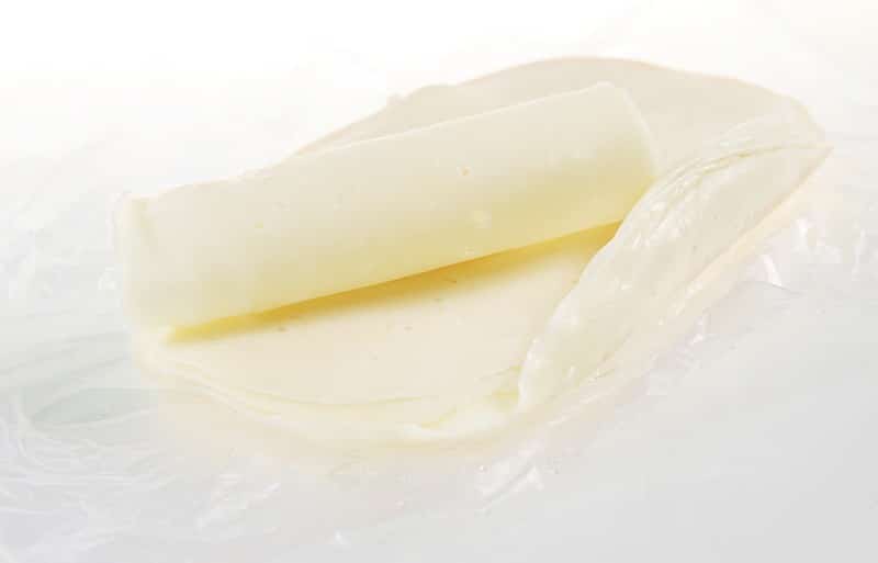 Deli Sliced Baby Swiss Cheese on White Countertop Food Picture