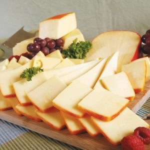 Sliced Muenster Cheese with Grapes and Garnish on Wooden Board Food Picture