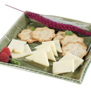 Swiss Cheese with Crackers and Garnish on Green Plate Food Picture