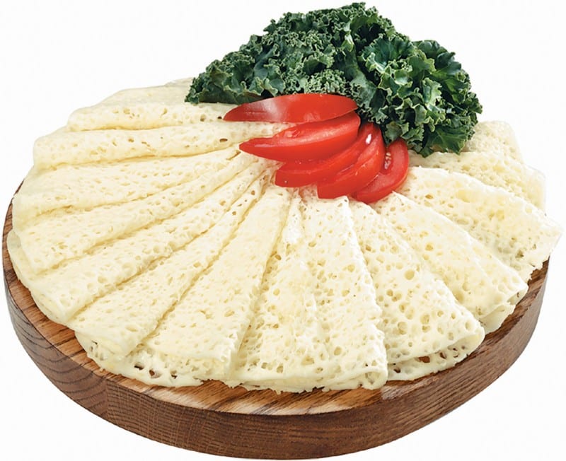 Thin Sliced Swiss Cheese with Garnish on Wooden Board Food Picture