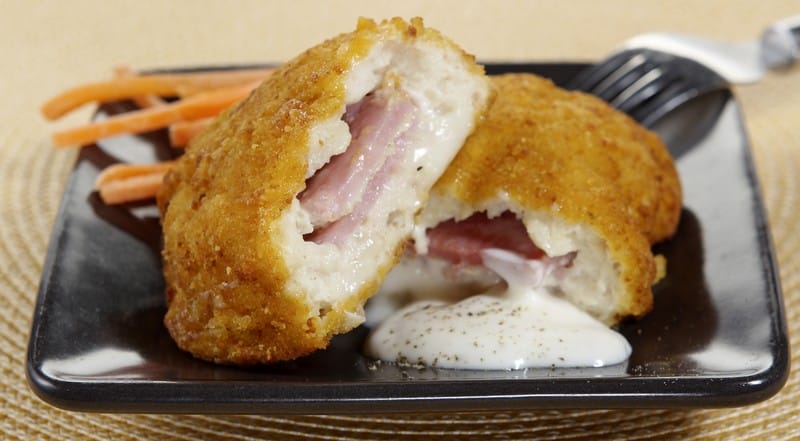 Fresh Country Fried Chicken Cordon Bleu with Gooey Cheese on Black Ceramic Plate with Carrot Shreds Food Picture