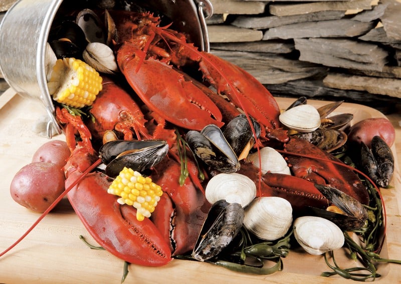Clambake On Wooden Board In Front Of Rocks Food Picture