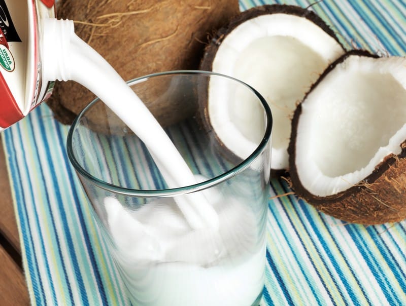 Someone Pouring Coconut Milk into a Glass Food Picture
