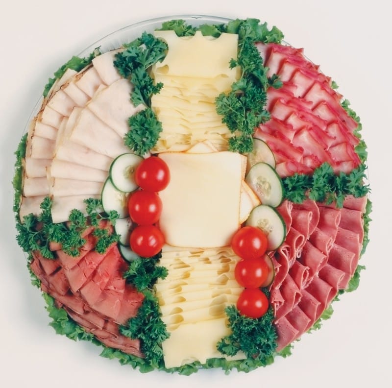 Cold Cut Assortment over Greens with Veggie Garnish on Clear Tray Food Picture