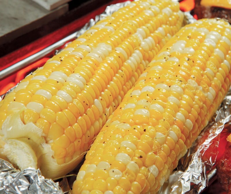 Grilled corn on the cob with seasoning in foil Food Picture