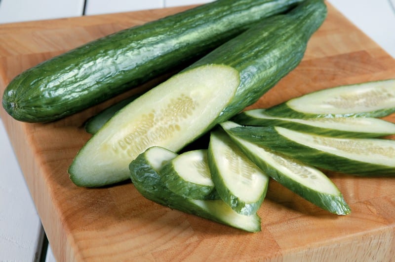 Whole and Sliced English Cucumbers on Board Food Picture