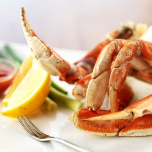 Boiled Dungeness Crab Legs with Cocktail Sauce and Lemon Wedges Food Picture