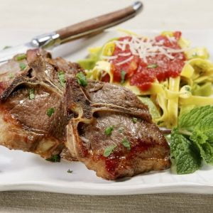 Cooked Lamb Chops with Mint Garnish and a Side of Pasta Food Picture