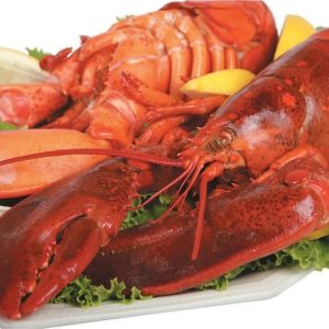Two Cooked Lobsters Over Lettuce on Plate with Lemon Slices Food Picture