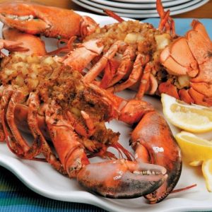Baked stuffed lobster with lemon wedges on white plate Food Picture
