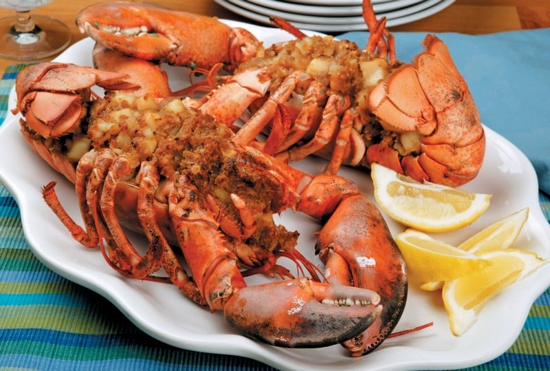 Baked stuffed lobster with lemon wedges on white plate Food Picture