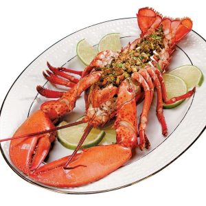 Baked stuffed lobster with lime garnish on white plate Food Picture