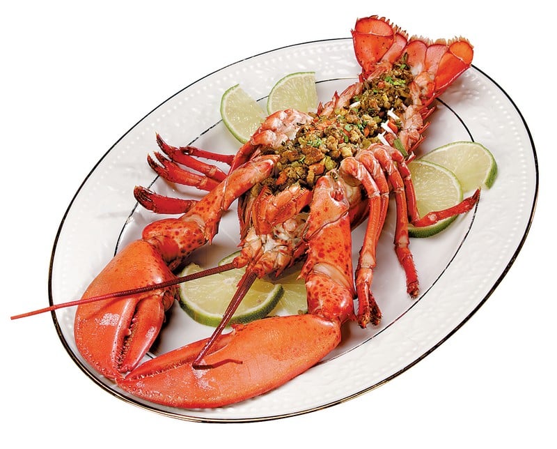 Baked stuffed lobster with lime garnish on white plate Food Picture