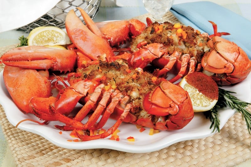 Baked stuffed lobster with garnish on white plate and tan placemat Food Picture