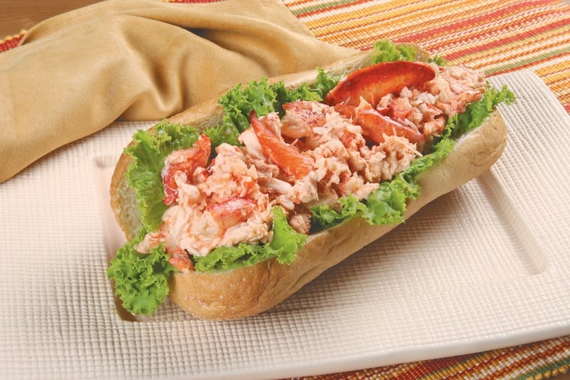 Open-faced lobster roll with lettuce on green plate Food Picture