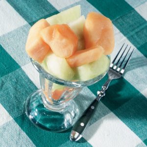 A Melon Cup with a Fork and Plaid Tablecloth Food Picture
