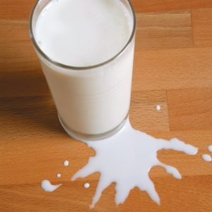 Glass of Milk with Spilt Milk on Wooden Surface Food Picture