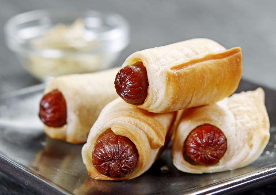 Baked Pigs in a Blanket Sausage Appetizers on Ceramic Black Plate with Dipping Sauce Food Picture