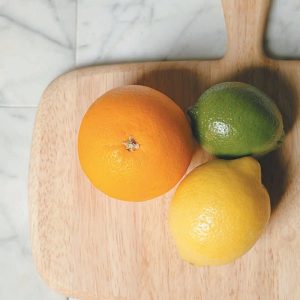 An Orange A Lime and A Lemon on a Cutting Board Food Picture