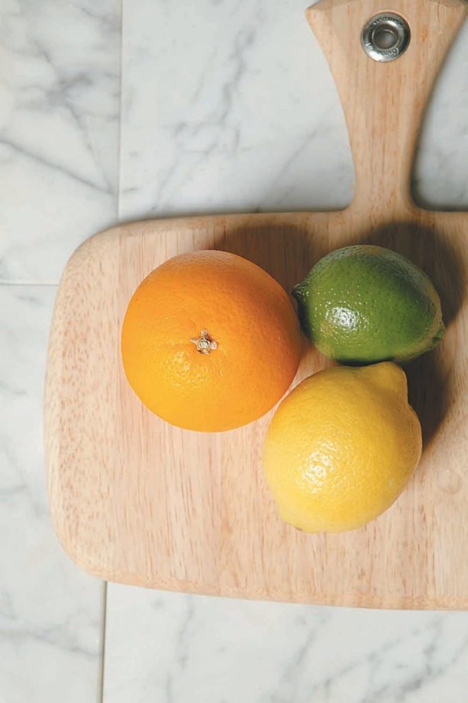 An Orange A Lime and A Lemon on a Cutting Board Food Picture