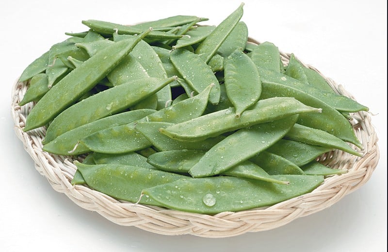 Snow peas in a wicker basket on a white background Food Picture