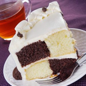 Wedge of Chocolate Vanilla Checkerboard Black White Cake with Vanilla Icing on Ceramic White Plate Food Picture