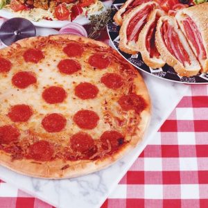 Pepperoni Pizza and Calzone on Marble Slab and Red Checkered Cloth Food Picture