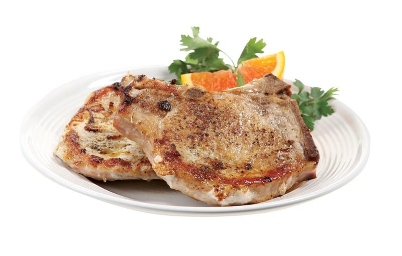Pork Chops on a Plate with an Orange Slice Food Picture