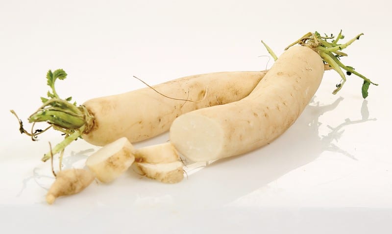 Daikon Radishes with Slices on White Surface Food Picture