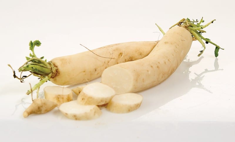 Daikon Radishes with Slices on White Surface Food Picture