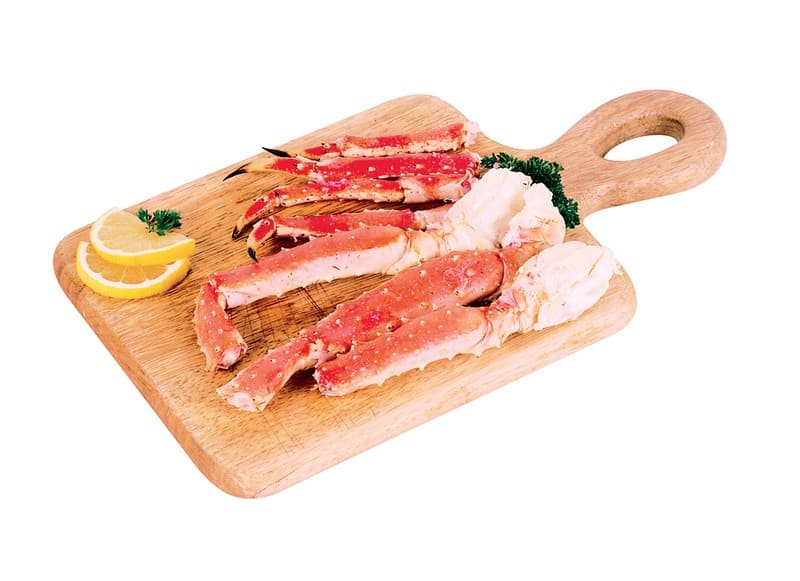 Raw Alaskan Crab Leg with Garnish on Wooden Surface Food Picture