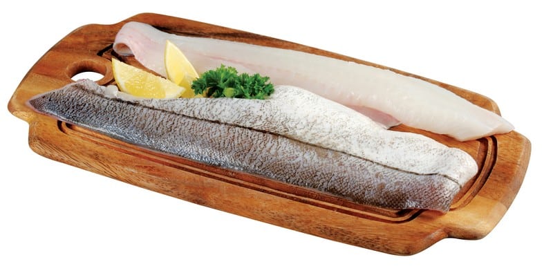 Haddock fillet on wooden board with garnish Food Picture
