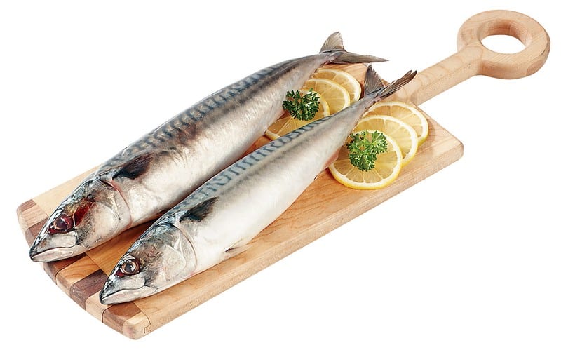 Whole Mackerel on wooden slab with garnish Food Picture