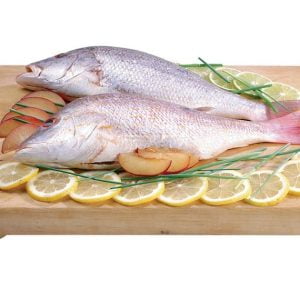 Whole red snapper with garnish on wooden slab with white background Food Picture