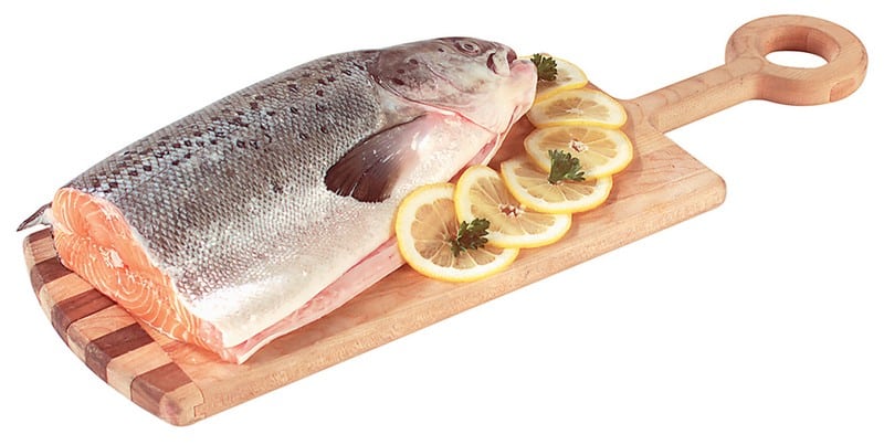Half alaskan salmon with lemon on wooden board and a white background Food Picture