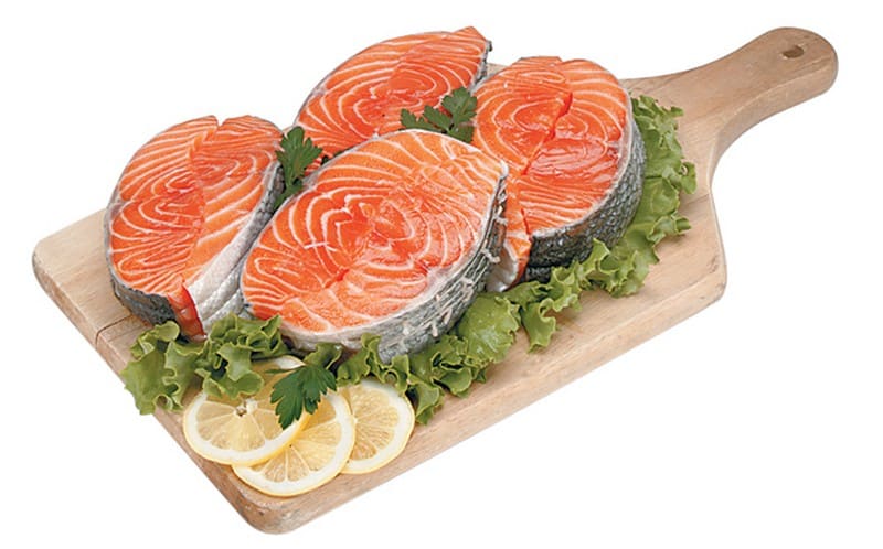 Salmon steaks on wooden board with garnish on white background Food Picture