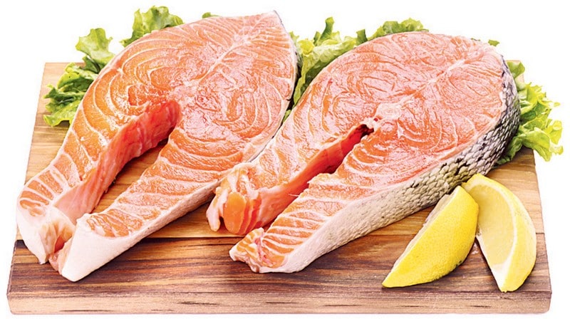 Salmon steaks on a wooden board with garnish and a white background Food Picture