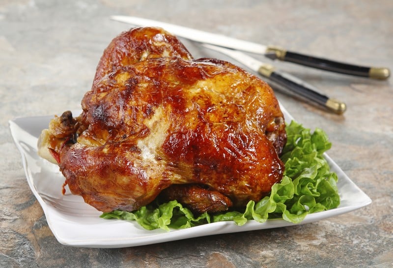 Fresh Roasted Rotisserie Chicken on Porcelain Platter with Carving Knives on Slate Countertop Food Picture