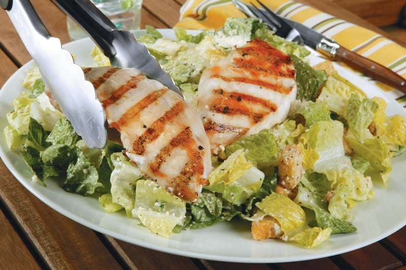 Chicken Caesar Salad on White Plate with Silver Tongs Food Picture