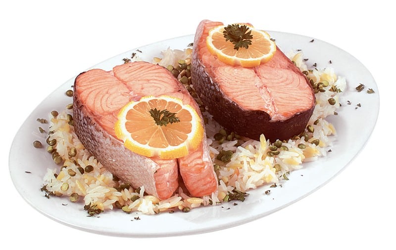 Salmon Steaks over Rice with Garnish on White Plate Food Picture